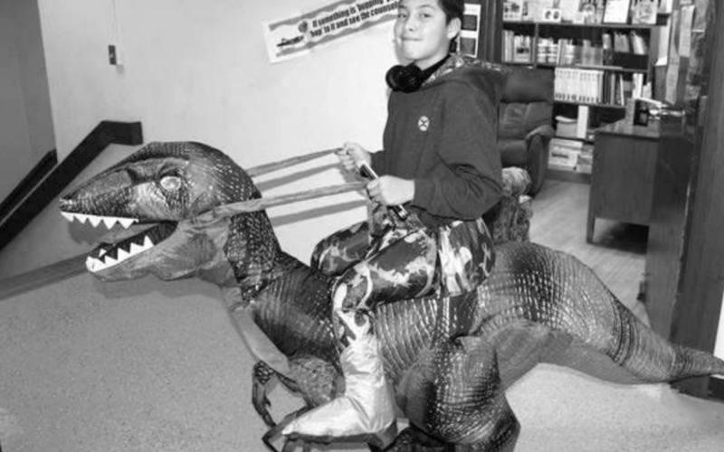 Levi Elk Nation riding a dinosaur through the hallways.