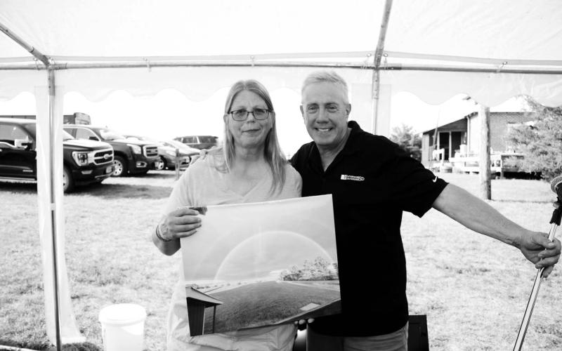 Paul Hanson (RIGHT) presented Teri Gayer with a photo of a rainbow at Klein Ranch during a celebration honoring her on July 22. Photo by Roger Lawien