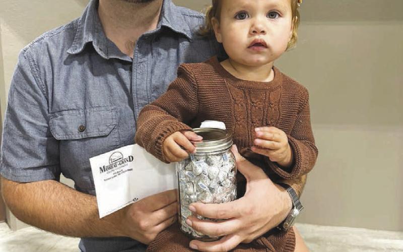 ABOVE: Jeanne Shupick, pictured with her dad, Matthew, won the kids’ prize drawing of $25 and a jar of candy.