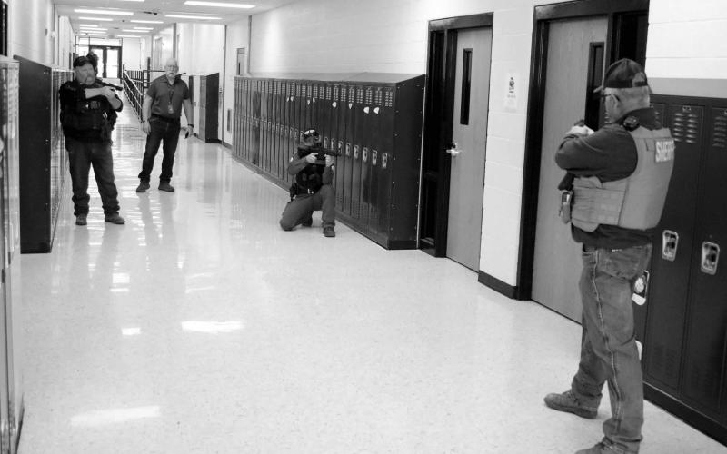 The Dupree School held an active shooter drill last week which involved evacuating staff and students from the building while law enforcement searched for and apprehended a lone gunman. Focused on a room where the shooter barricaded himself are l-r Ziebach County Deputy Mike Denavi; Dupree School Dean of Students/Truancy/Emergency Manager Shannon Hinrichs, CRST Police Officer Jeremy Reede and Ziebach County Sheriff Gary Cudmore. Photo by Jon Flatland