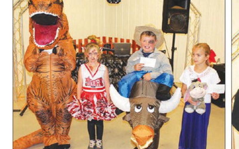 ABOVE: In the 7-12 years old category, these costumes took home the cash prizes. (L-R): Dinosaur Pace Stambach with Most Original, Scariest went to cheerleader Saylem Stambach, Most Humorous to Royce Grueb, and Most Adorable to Kinleigh Brooks. Photos by Patty Peacock