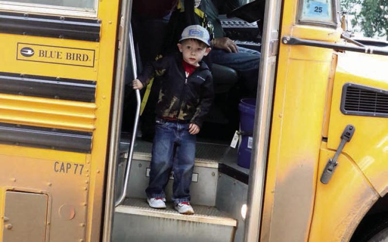 Pre-Kindergarten student Kazmer Lamb, son of Kritter and Kamy Lamb, wasn’t sure what to make of his bus ride to the first day of school on Tuesday or why there was a guy with a camera waiting for him when the bus doors opened but he slowly worked up the confidence to step off the bus and enter the school. Photo by Jon Flatland