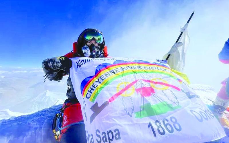 Rapid City surgeon Dr. Jacob Weasel unfurls the CRST flag while atop Mount Everest