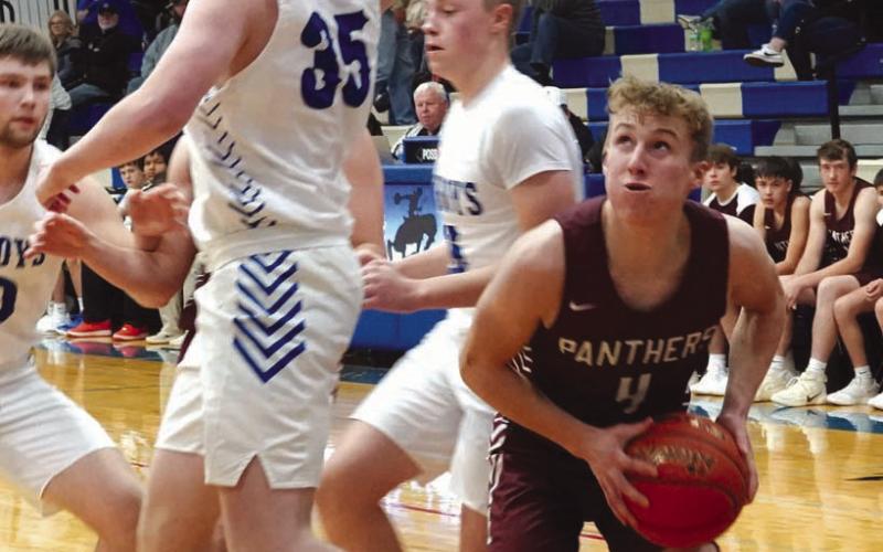 Senior guard Gracen Hansen (4) pump fakes Lemmon defender Sawyer Thompson (35) under the basket during the boys basketball season opener for both teams last Friday, Dec. 8. Timber Lake rallied late but ended up taking a 58-54 loss. Photo courtesy of Marie Du Preez
