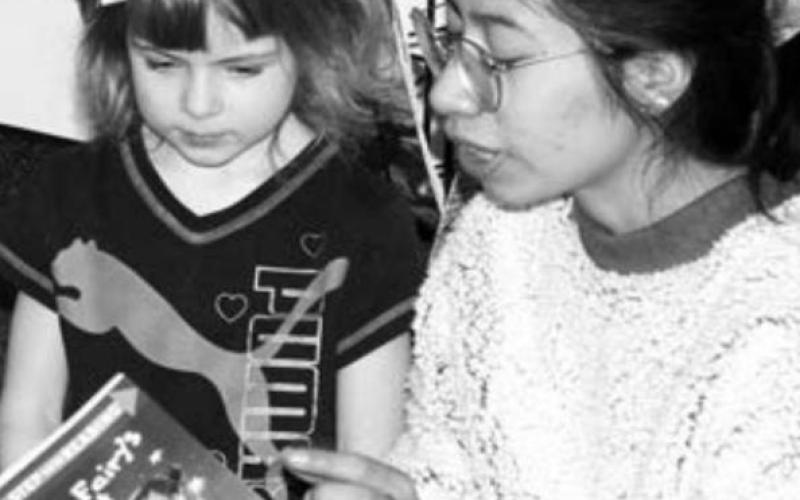 Megan Hinrichs, and NHS member, reading to PreK student Koraline Pesicka.