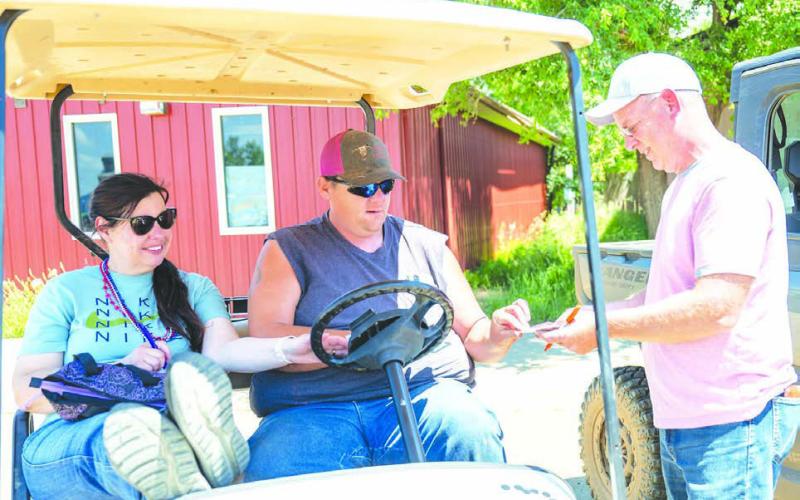 Jenny and Slade Farlee buy a Poker Run ticket from Shawn Olsen Photos by Kathy Olsen