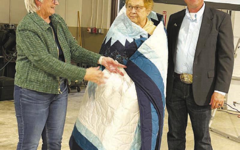 Moreau-Grand board members Geralyn Hahne (left) and Kerry McLellan (right) presented a star quilt to Lois Bartlett in recognition of her 18 years on the board. Paul Lawrence was not in attendance to receive a star quilt after serving 25 years.