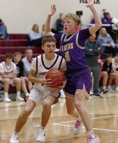 Panther guard Kruz Lindskov gets bumped by a New Underwood defender as he works his way along the baseline . Find more boys and girls basketball coverage on Pages 8 and 9. Topic Photo/Marie DuPreez