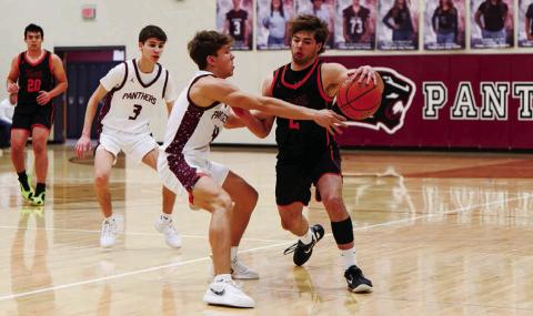 Timber Lake’s Broc Bauer reaches for a steal against a Faith player while Braden Lawrence (3) looks on during a Little Moreau Conference matchup in Timber Lake last week. The Panthers won to improve to 5-2 on the season. Topic Photo/Marie DuPreez