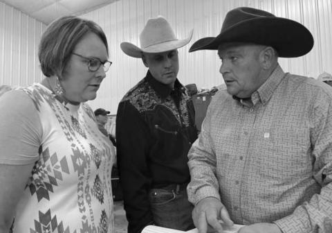 Laurie Bickel, Levi Goldade and John Hoven check the list of items for the live auction.