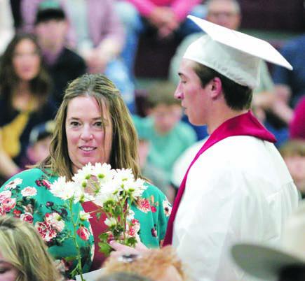Exchange student Francesco Barbini from Italy presents flowers to his host parent, Leah Peterson.