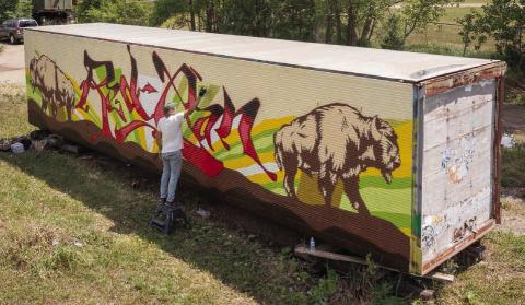 An artist works on a mural in Eagle Butte during the 2022 RedCan Graffiti Jam. The 9th annual event got underway Wednesday and continues through Saturday. (Photo by CRYP)