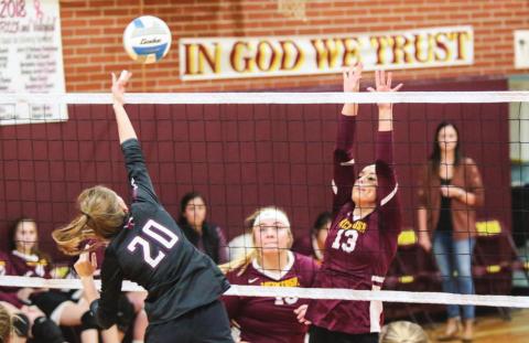 Timber Lake middle hitter Molly Kraft (20) powers a spike past the defense of Mcintosh's Meghan Maher (13) and Reyna Nehl (15) during varsity volleyball action on Oct. 1 in Mcintosh. Photos by Jon Flatland