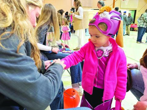 Payton Bollinger, daughter of Shad Bollinger and Kelly Laurenz, was ready for trick-or-treating in her Paw Patrol costume, while getting a temporary tattoo at the Dewey County 4-H Halloween Carnival in Timber Lake on Sunday, Oct. 29. Turn to Page 9 for more photos from the carnival. Photo by Kathy Nelson