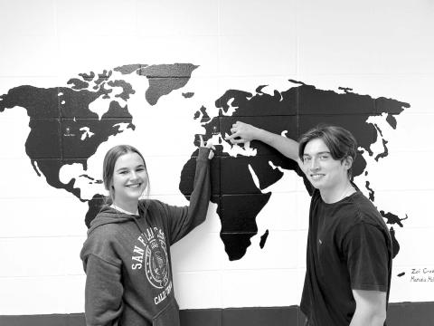 Exchange students Carla del Rio Larrea (LEFT) and Francesco Barbini point to their homes in Spain and Italy. The map was painted in the hallway at Timber Lake High School by last year’s exchange students.