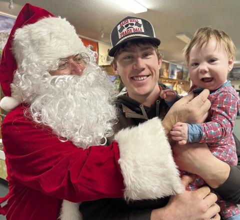 J.D. Enright introduces his baby boy, Denver Richard, to the “jolly old elf ” at the Timber Lake Museum on Monday. Santa and Mrs. Claus visited with about 70 children. Their visit and other Community Christmas activities were sponsored by Timber Lake Area Development and Western Dakota Bank. Topic Photo/Kathy Nelson