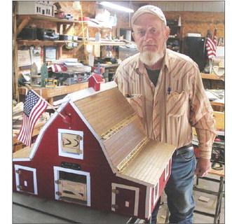 Dave Doan with one of his handcrafted barns. Photo by Jon Flatland