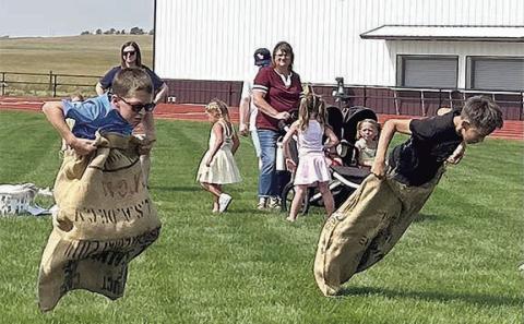 Lincoln Aberle (left) and Gunner O’Leary (right) racing to the finish in the potato sack race. Photo By Ann Arnold