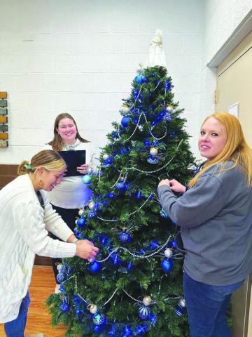 One of the Christmas trees at the Dewey County Courthouse is being decorated by (L-R) Auditor Jamalia Franzen, Deputy Equalization Director Zoe Olson, and Deputy Register of Deeds Fallon Bad Warrior.