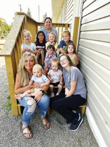 Stacy Keller (front, left) is the new interim director of Timber Lake Community Daycare. She is pictured holding Carsyn Leibel. Colty Claymore is at right with Kasen Pay Pay. In the middle row are (l-r) Marin Maher, John Booth, and Jensen Booth. In back are Kian Rousseau, Christina Rousseau, Autym Jones, and Wren Jones.