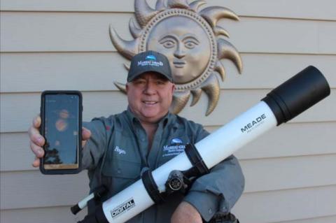 Amateur astronomer Roger Lawien shows off his telescope and the cellular telephone app he uses to help him find planets, stars and constellations. Photo by Jon Flatland
