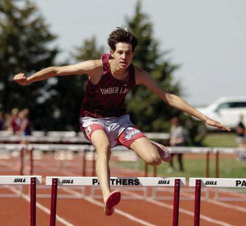 AT LEFT: Jackson Bigger clears a bar enroute to a first place finish in the 300 meter hurdles.  Photo by Marie DuPreez