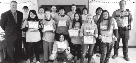 McIntosh DARE graduation. FRONT (L-R): Guest speaker Shane Penfield, Mileigh Eagle, Mia Hanson, Olivia Geigle, Jessmyn Hertel, Kaitlyn Lynch, Abundance Bjornstad; BACK: Dominick Klein, Adam Jaragoske, Wyatt Larson, Carmelo Little Eagle, Curtis Conner, Ozziah Ulmer, Corey Flying Bye, Corson Co. Sheriff Alan Dale.