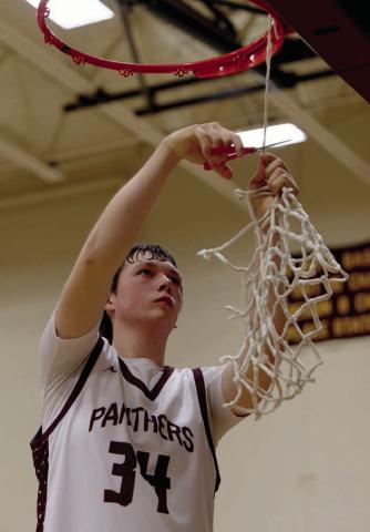 Rance Martin, the only senior on Timber Lake’s boys basketball team this season, cuts down the net after the Panthers beat Faith last Friday to advance to the SoDak 16. Topic Photo/Marie DuPreez