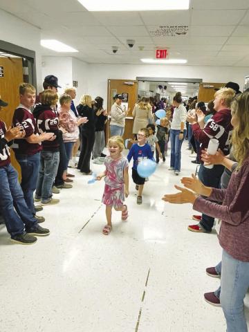 Photo by Kathy Nelson Timber Lake Elementary students and staff, waving blue ribbons and balloons, paraded through the hallways on Monday as high school and middle school students and staff cheered for them in celebration of their recognition as a National Blue Ribbon School. Here Rose Maher and Lincoln Aberle lead the parade.