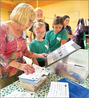 Judge Adele Enright looks at photography entries with Stella Nilson and Finley Boldt at the Dewey County 4-H Achievement Day on July 27.