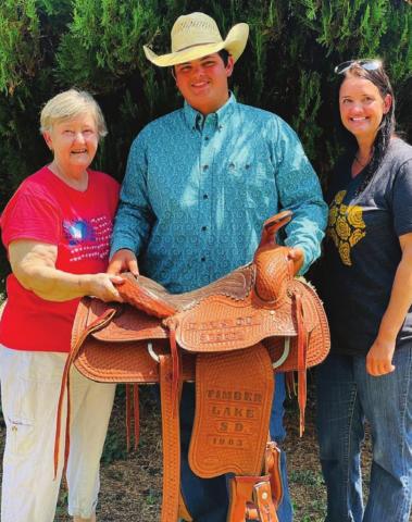 Carol Dellis (LEFT) with her daughter Sarah and 15-year-old grandson, Garrett, with the Days of 1910 saddle that Carol and her husband, Billy Bob Dellis, built in 1983. “It’s our legacy,” Carol said. “When it came I just hugged it. Just sitting here looking at it gives me such peace.”