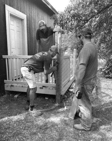 Volunteers work on fencing in the yard of a residence in McIntosh that is housing the new community daycare operation. The daycare opened Monday, Sept. 20, with its first seven children enrolled. Submitted photo