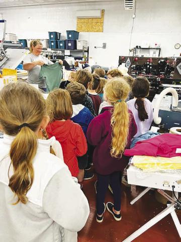 LEFT: Bobbie Jo Grage shows kids how tshirt printing is done during their field trip to Dakota Image.