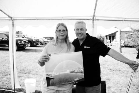 Paul Hanson (RIGHT) presented Teri Gayer with a photo of a rainbow at Klein Ranch during a celebration honoring her on July 22. Photo by Roger Lawien