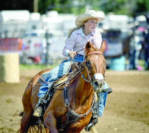 Korbi Heck, left, runs her horse through the Sr. Barrels at the State 4-H Finals Rodeo. She placed eighth overall in the event to wrap up a successful season.