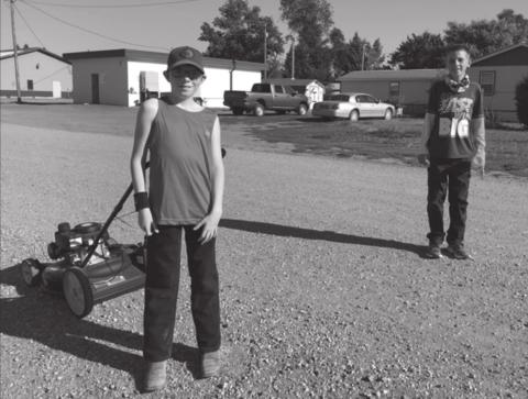Johnny Hoyt (LEFT) and Adam Meier, on the way to a lawn mowing job after school, show how it is to stand six feet apart.