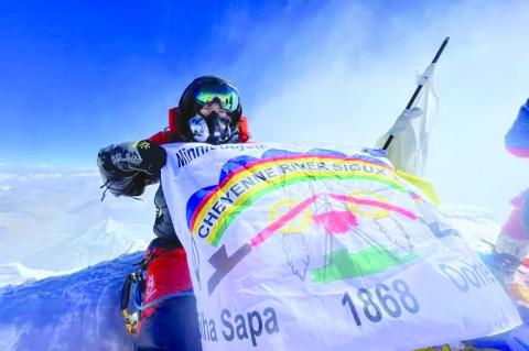 Rapid City surgeon Dr. Jacob Weasel unfurls the CRST flag while atop Mount Everest
