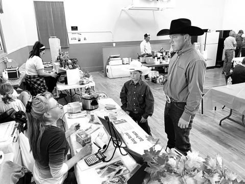 Melody Marshall of rural Timber Lake (LEFT) talks about her goat meat products with Justin Thompson and son of rural Mobridge. Photos by Kathy Nelson