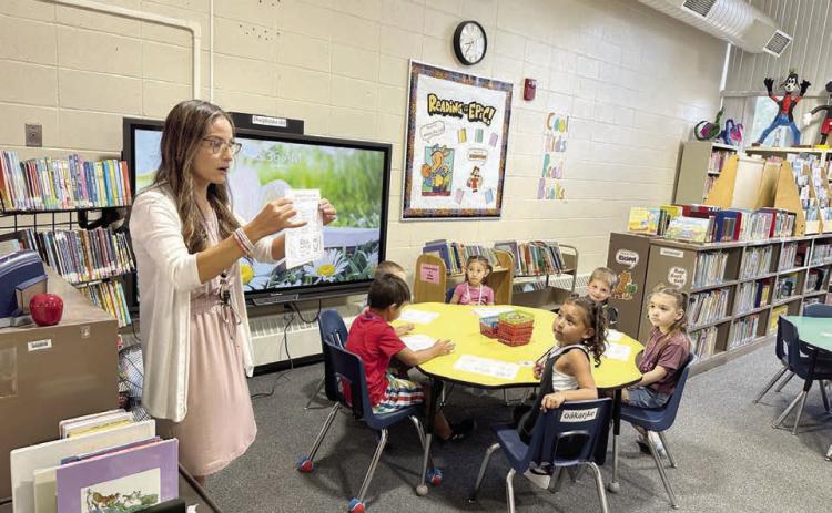 Timber Lake School librarian LeAnn Thompson was ready for students on the first day of school on Monday, Aug. 18. Here she tells Kindergarteners that they can check out books to take home and introduces them to the rules on how to care for books. Photo by Kathy Nelson