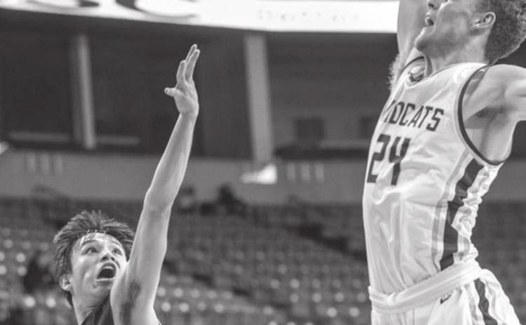 McLaughlin’s Evan Archambault tries to float a shot over the defense of Custer’s 6’5” center Gage Tennyson during the Lakota Nation Invitational. Photo by Robert Slocum