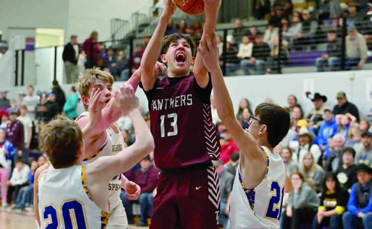 Panther forward Jackson Bigger (13) drives to the hoop between a pair of Wessington Springs defenders during the SoDak 16 matchup between Timber Lake and the Spartans. Photo by Marie DuPreez
