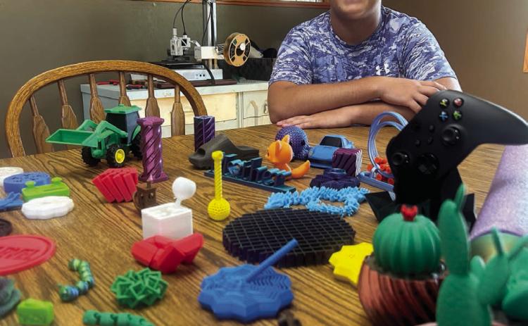 Self-taught toy manufacturer Evan Schweitzer, 16, shows off just a few of the 100-or-so fidget spinner designs he has made and currently offers for sale. Fidget spinners - popular about 10 years ago, are making a comeback, he says, not just as toys but to help those with ADHD, anxiety, autism and more. Photo by Jon Flatland