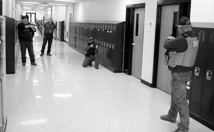The Dupree School held an active shooter drill last week which involved evacuating staff and students from the building while law enforcement searched for and apprehended a lone gunman. Focused on a room where the shooter barricaded himself are l-r Ziebach County Deputy Mike Denavi; Dupree School Dean of Students/Truancy/Emergency Manager Shannon Hinrichs, CRST Police Officer Jeremy Reede and Ziebach County Sheriff Gary Cudmore. Photo by Jon Flatland