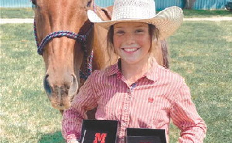 Korbi Heck of Isabel and her horse, Jetta, won both the Junior Girls Barrel Racing and Junior Girls Pole Bending championships on Saturday, July 8, at the Harding County 4-H Rodeo in Buffalo. Heck is one of several area competitors to garner gold buckles at the event.
